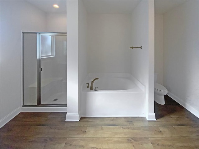 bathroom with hardwood / wood-style flooring, plus walk in shower, and toilet