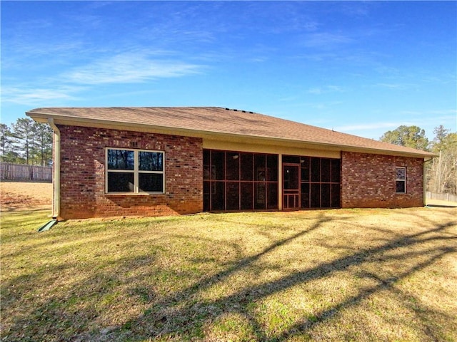 rear view of property featuring a lawn