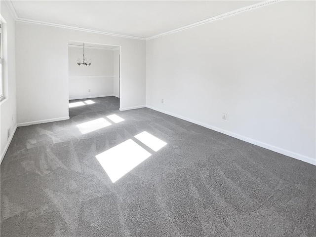 empty room with crown molding, a chandelier, and dark colored carpet