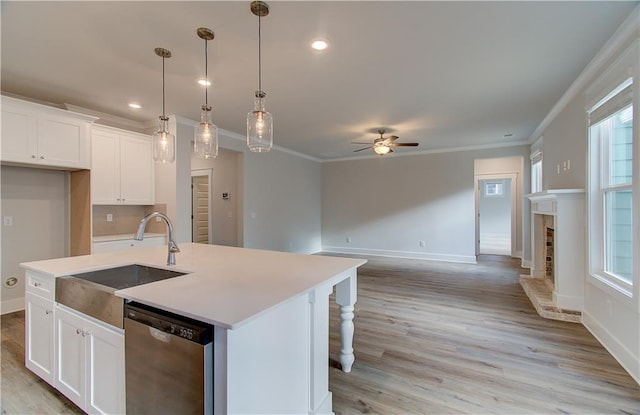 kitchen with a ceiling fan, a sink, ornamental molding, white cabinets, and dishwasher