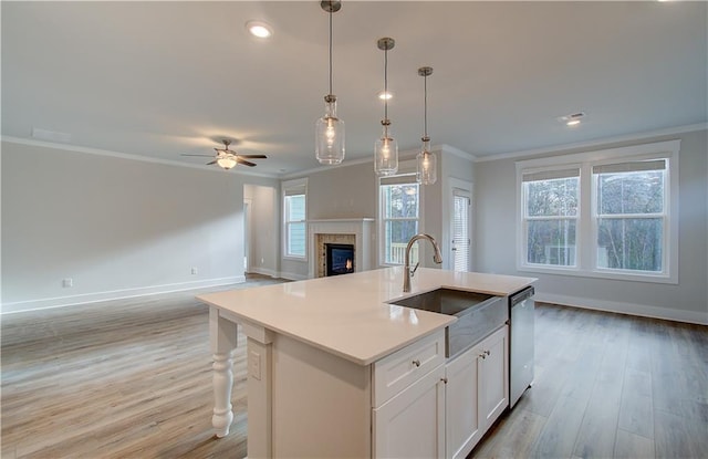 kitchen with dishwasher, crown molding, open floor plan, and a sink