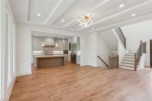 7188 Williams Rd, Flowery Branch, GA 30542 - unfurnished living room featuring light wood-type flooring, a chandelier, recessed lighting, beamed ceiling, and a sink