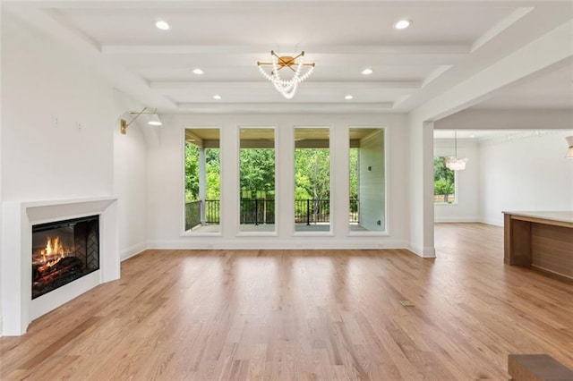 7188 Williams Rd, Flowery Branch, GA 30542 - unfurnished living room with a chandelier, a glass covered fireplace, beamed ceiling, light wood-style floors, and baseboards