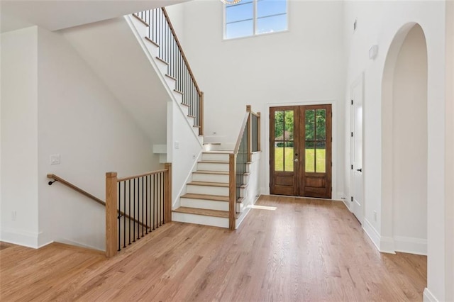 7188 Williams Rd, Flowery Branch, GA 30542 - entrance foyer featuring wood finished floors, plenty of natural light, a towering ceiling, french doors, and baseboards