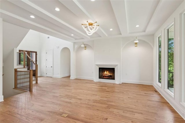 7188 Williams Rd, Flowery Branch, GA 30542 - unfurnished living room with light wood-style flooring, recessed lighting, arched walkways, a lit fireplace, and baseboards