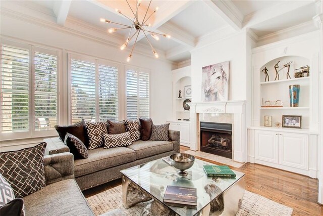 living room featuring coffered ceiling, light wood-style floors, built in features, ornamental molding, and beam ceiling