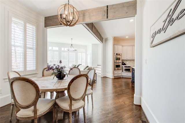 dining space featuring a chandelier, dark wood finished floors, and baseboards