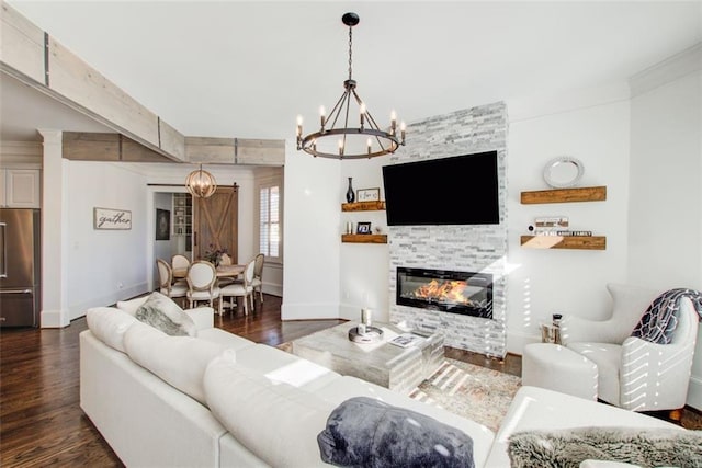 living room with a chandelier, a fireplace, dark wood finished floors, and baseboards