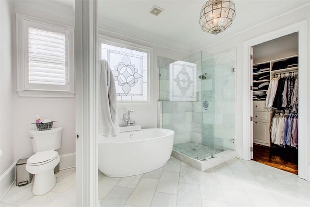 bathroom featuring visible vents, a soaking tub, ornamental molding, a spacious closet, and a shower stall