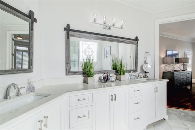 full bath featuring double vanity, tile patterned flooring, crown molding, and a sink