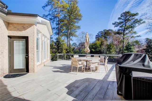 deck featuring outdoor dining space and grilling area