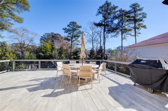 wooden terrace with outdoor dining space and grilling area