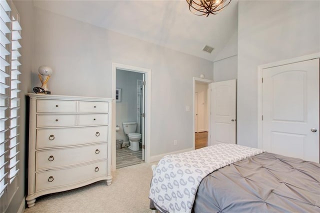 bedroom featuring visible vents, baseboards, light colored carpet, ensuite bath, and vaulted ceiling