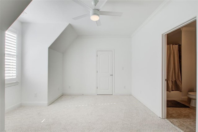 bonus room with light colored carpet, ceiling fan, and baseboards