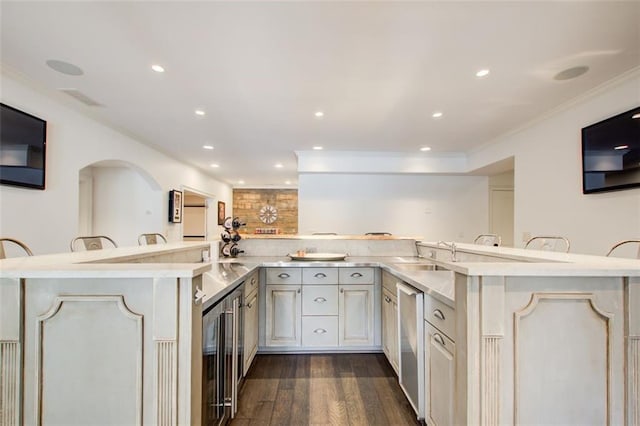 kitchen featuring a sink, a breakfast bar, dishwasher, and open floor plan