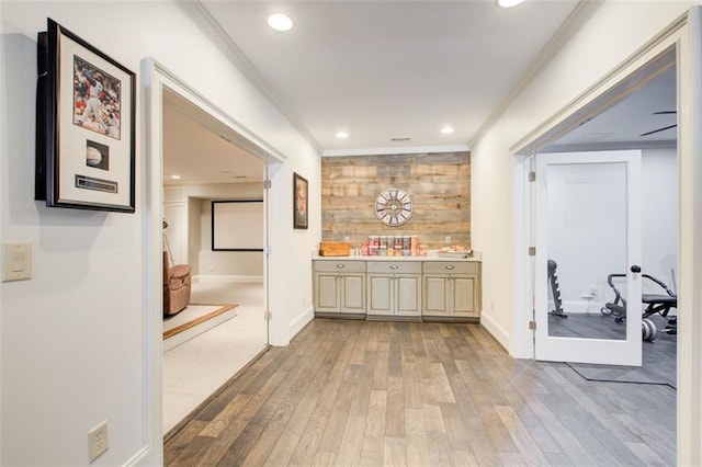 hallway featuring crown molding, recessed lighting, baseboards, and light wood-style floors