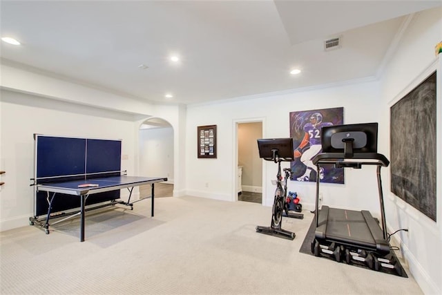 exercise area featuring arched walkways, visible vents, light carpet, and recessed lighting