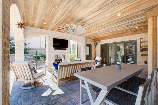 view of patio featuring an outdoor living space with a fireplace, a ceiling fan, and outdoor dining space