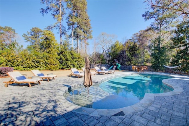 view of swimming pool with a patio, a playground, a fenced backyard, and a fenced in pool