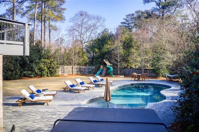 view of swimming pool with a patio area, a playground, a fenced backyard, and a fenced in pool