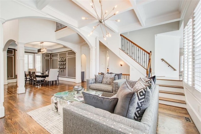 living area featuring decorative columns, visible vents, coffered ceiling, wood finished floors, and beam ceiling