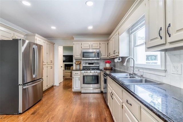 3664 Maple Forge Ln, Gainesville, GA 30504 - kitchen with appliances with stainless steel finishes, dark countertops, ornamental molding, decorative backsplash, and wood finished floors