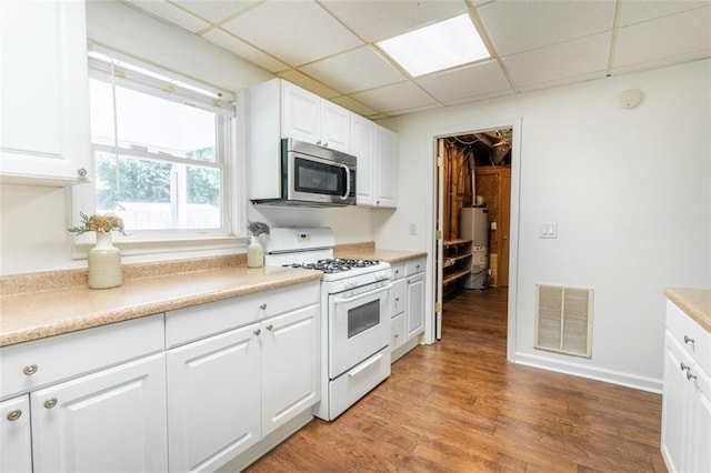 3664 Maple Forge Ln, Gainesville, GA 30504 - kitchen featuring stainless steel microwave, white range with gas cooktop, water heater, white cabinets, and a paneled ceiling
