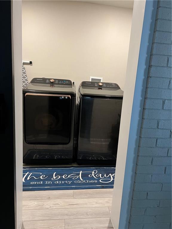 laundry room featuring laundry area, independent washer and dryer, and wood finished floors