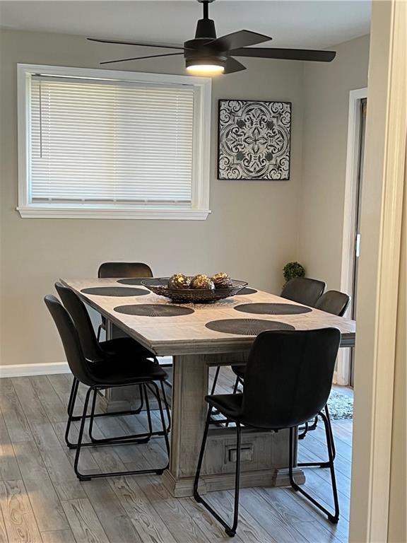 dining space with ceiling fan, baseboards, and wood finished floors