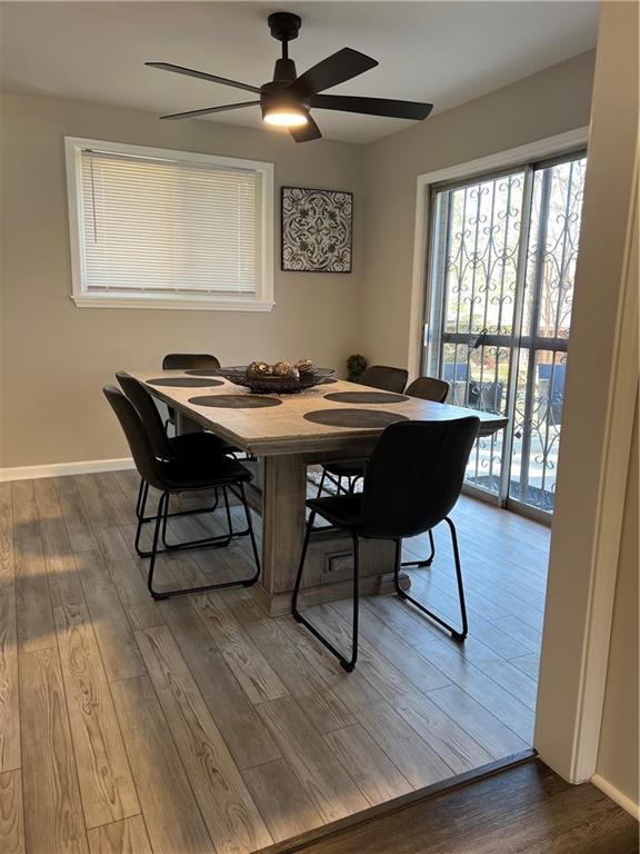 dining space featuring a ceiling fan, wood finished floors, and baseboards