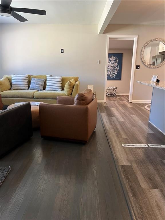 living area with ceiling fan, baseboards, and wood finished floors