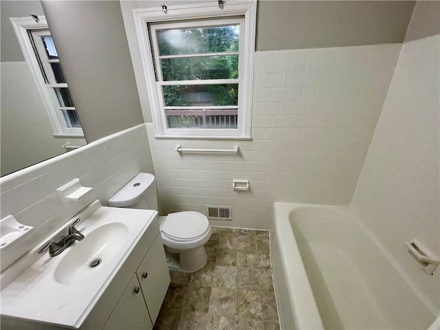 25 Gladstone Dr SW, Marietta, GA 30060 - bathroom featuring tile walls, a tub to relax in, vanity, and a wainscoted wall