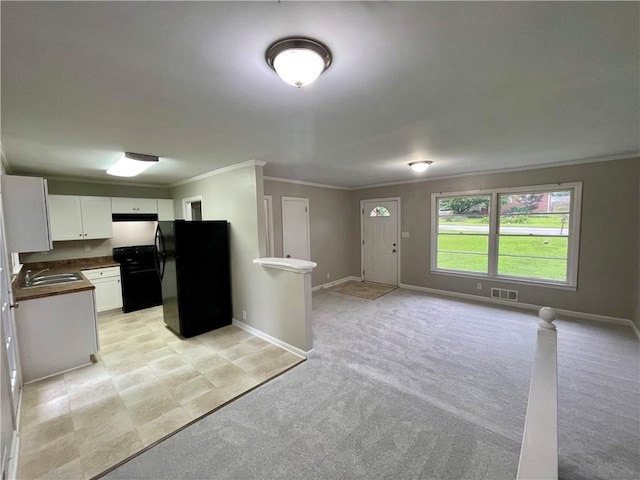 25 Gladstone Dr SW, Marietta, GA 30060 - kitchen featuring freestanding refrigerator, open floor plan, crown molding, dark countertops, and white cabinets