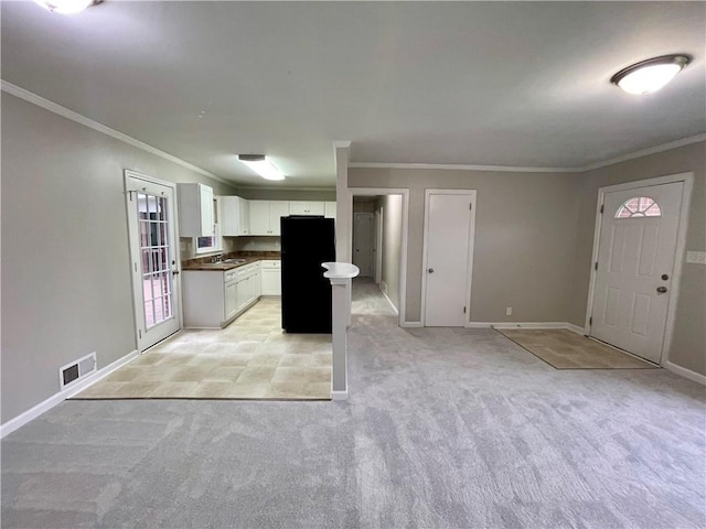 25 Gladstone Dr SW, Marietta, GA 30060 - kitchen featuring freestanding refrigerator, light colored carpet, open floor plan, ornamental molding, and white cabinetry