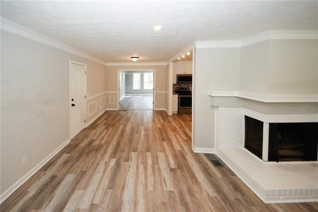 hallway with hardwood / wood-style flooring, crown molding, and a textured ceiling