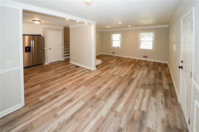 spare room featuring light hardwood / wood-style flooring and ornamental molding