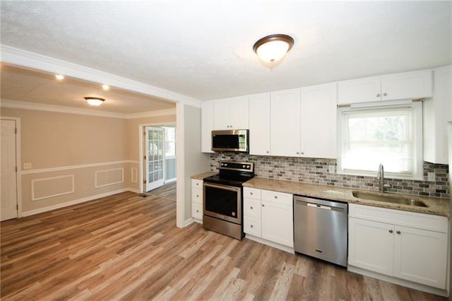 kitchen featuring light wood-type flooring, a wealth of natural light, appliances with stainless steel finishes, and sink