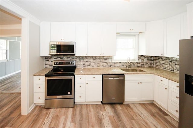 kitchen featuring appliances with stainless steel finishes, light hardwood / wood-style flooring, and a wealth of natural light