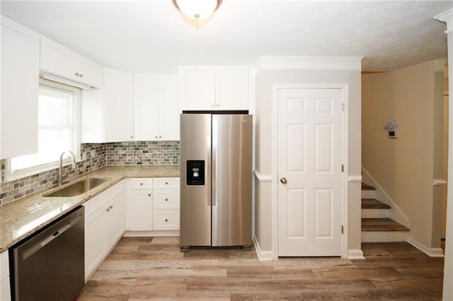 kitchen with sink, backsplash, light wood-type flooring, and stainless steel appliances