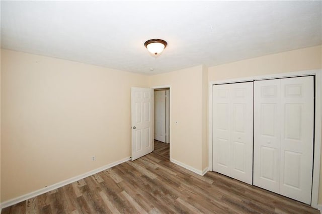 unfurnished bedroom with a closet and hardwood / wood-style flooring