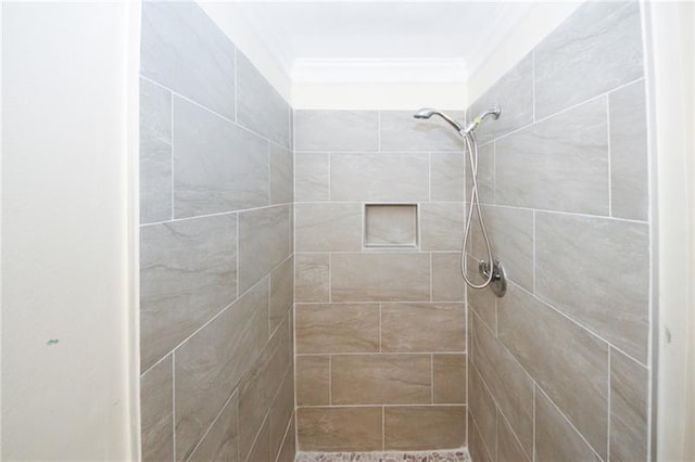 bathroom featuring tiled shower and crown molding