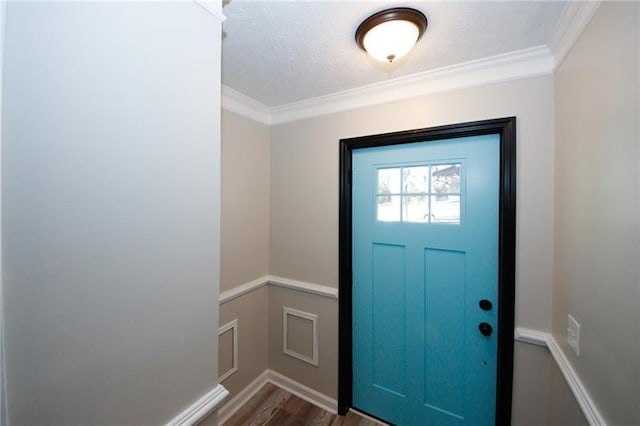 entryway with a textured ceiling, dark hardwood / wood-style flooring, and ornamental molding