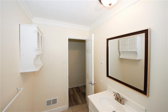 bathroom featuring hardwood / wood-style floors, sink, and ornamental molding