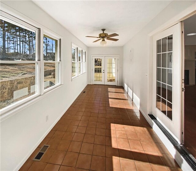 unfurnished sunroom with visible vents, french doors, and ceiling fan