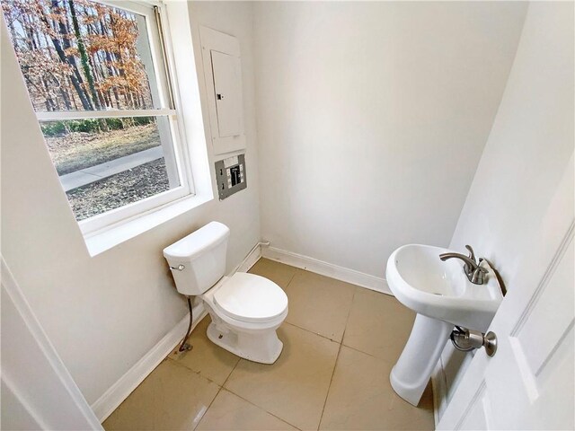 bathroom with tile patterned floors, toilet, and baseboards