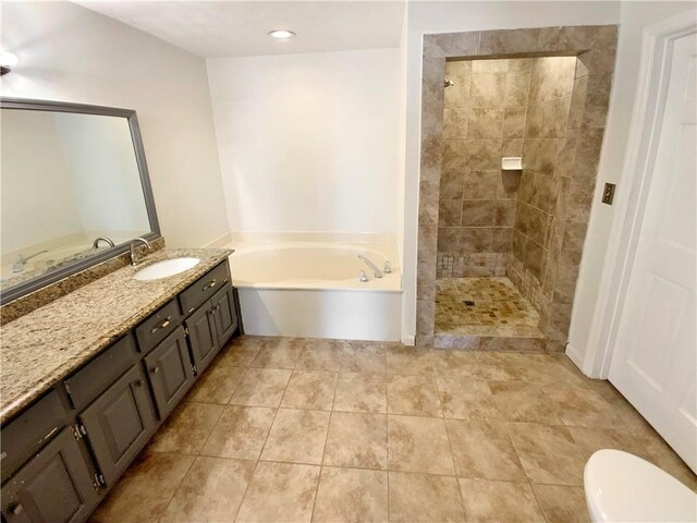 full bathroom with tiled shower, toilet, a bath, and vanity