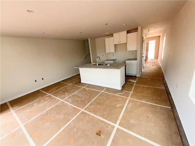 11596 E Lovejoy Rd, Hampton, GA 30228 - kitchen with a sink, white cabinetry, a center island with sink, and baseboards