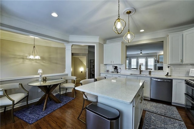 kitchen featuring a center island, sink, tasteful backsplash, white cabinets, and appliances with stainless steel finishes