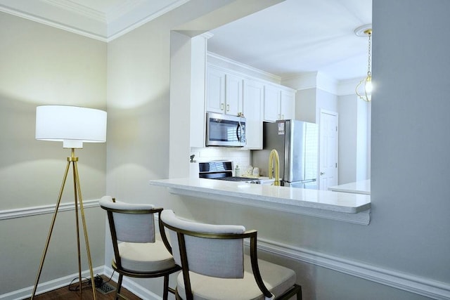 kitchen with tasteful backsplash, white cabinets, appliances with stainless steel finishes, light countertops, and crown molding