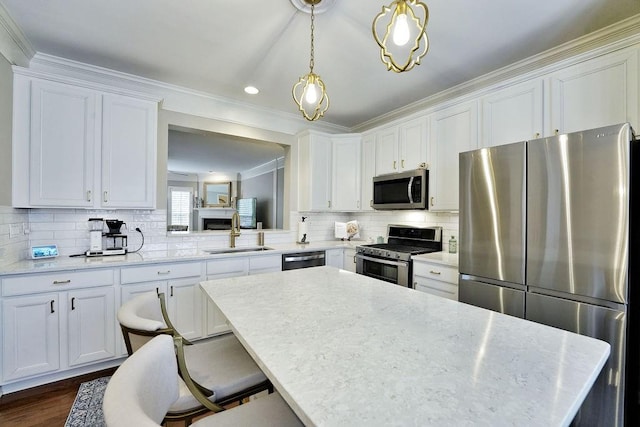 kitchen with white cabinetry, appliances with stainless steel finishes, and decorative light fixtures